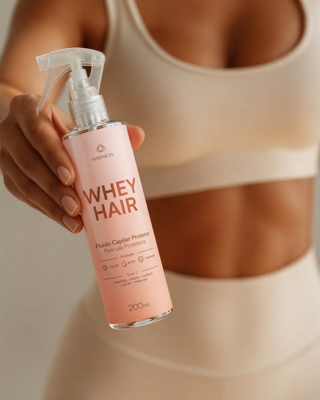 Mão segurando o Whey Hair 200 ml, fluido protetor da Harmon